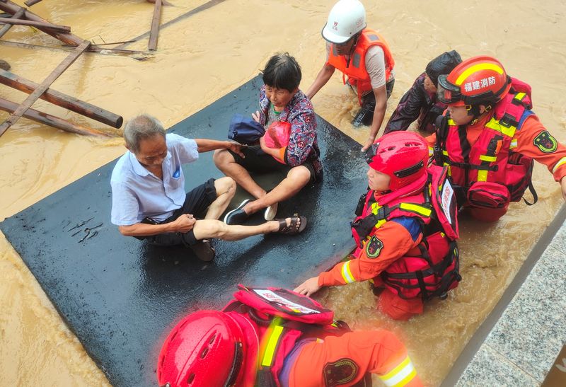 &copy; Reuters. Bombeiros retiram pessoas de casas inundadas após passagem do tufão Doksuri em Quanzhou, na China
28/07/2023
cnsphoto via REUTERS