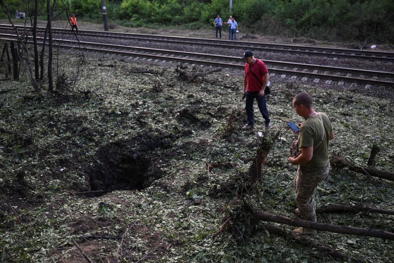 &copy; Reuters. سكان محليون يتفقدون آثار التخريب بعد قصف روسي على أوكرانيا في منطقة زابوريجيا يوم السبت. تصوير: فياتشيسلاف راتينسكي - رويترز.