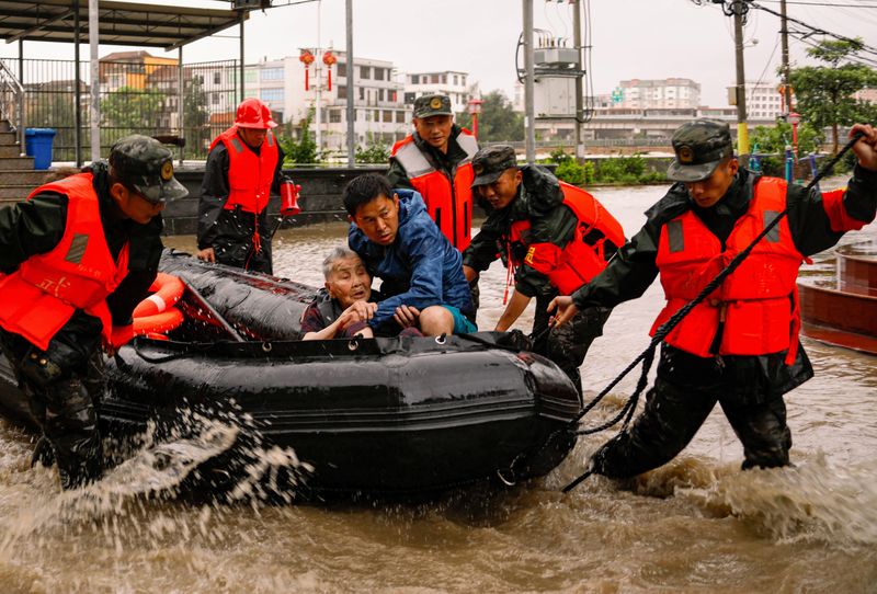 &copy; Reuters. Agentes de la policía paramilitar evacuan a los residentes varados por las inundaciones en el pueblo de Xincuo de la ciudad de Fuqing, después de que el tifón Doksuri tocó tierra y provocó fuertes lluvias en Fuzhou, provincia de Fujian, China. 29 de 