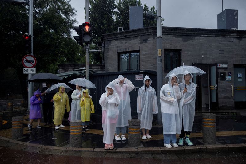 &copy; Reuters. Pedestres usam capa de chuva em região turística de Pequim
30/07/2023
REUTERS/Thomas Peter