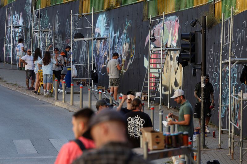 &copy; Reuters. فنانو الرسم على الجدران يرسممون لوحات جدارية كجزء من لقاء الأنماط الفنية في كوسوفو يوم 28 يوليو تموز 2023. تصوير: فاتوس بايتشتشي - رويترز.