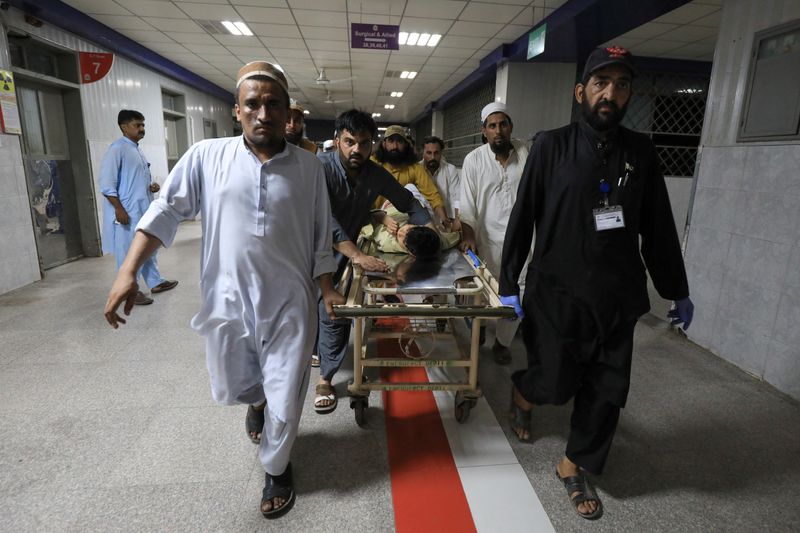 © Reuters. People transport a man, who was injured after a blast in Bajaur district of Khyber Pakhtunkhwa, at the Lady Reading Hospital in Peshawar, Pakistan July 30, 2023. REUTERS/Fayaz Aziz