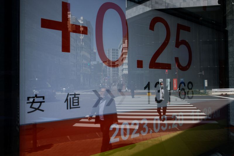 &copy; Reuters. FILE PHOTO: A reflection of passersby walking is seen on an electronic board showing Japan's Nikkei average outside a brokerage, in Tokyo, Japan, March 20, 2023. REUTERS/Androniki Christodoulou/File Photo
