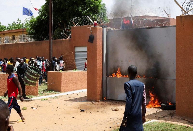 © Reuters. متظاهرون يدعمون الانقلاب يحاولون إحراق مبنى السفارة الفرنسية في نيامي عاصمة النيجر قبل أن  تفرقهم قوات الأمن يوم الأحد. تصوير: سليمان أج أنارة - رويترز. يحظر إعادة بيع الصورة أو وضعها في أرشيف . 