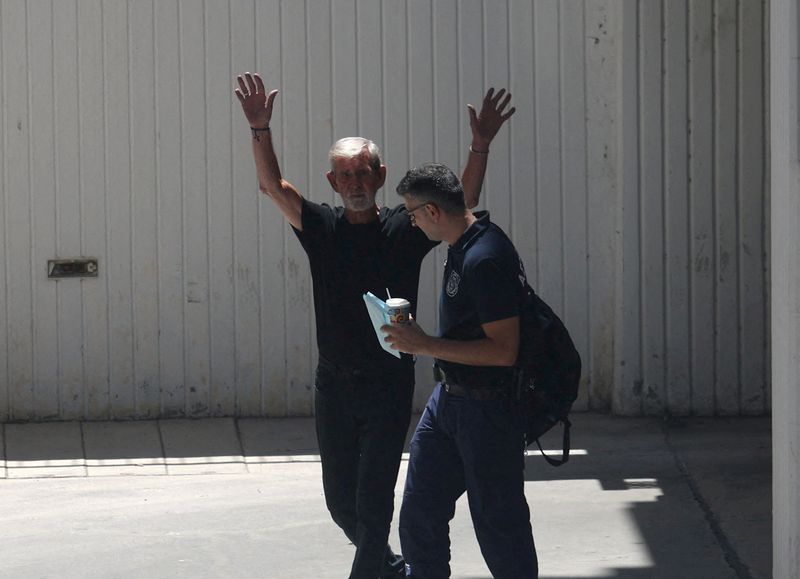&copy; Reuters. FILE PHOTO: British pensioner David Hunter waves to journalists while being escorted to a police van outside a courthouse in Paphos, Cyprus July 21, 2023. REUTERS/Yiannis Kourtoglou/File Photo