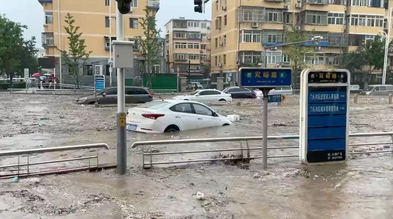 &copy; Reuters. Des voitures sont partiellement submergées dans une rue inondée, après que le typhon Doksuri ait apporté de fortes pluies, dans le district de Mentougou, à Pékin, en Chine. Image obtenue à partir d'une vidéo sur les médias sociaux. /Photo prise l