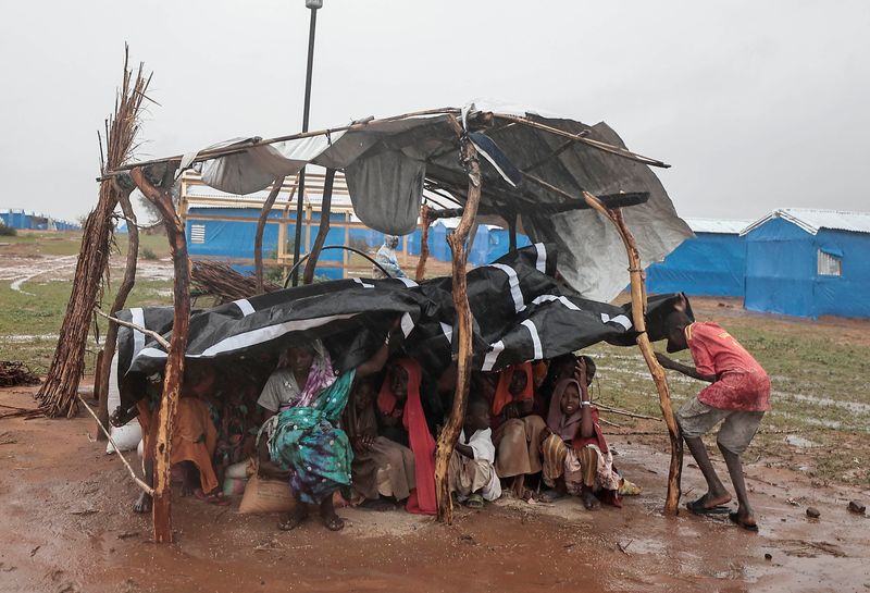 &copy; Reuters. سودانيون يحتموت من الأمطار أسفل خيمة في أحد المخيمات في أورانج بتشاد يوم الأحد. تصوير: زهرة بن سمرة - رويترز.