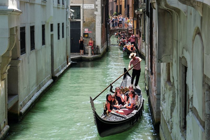 &copy; Reuters. زورق يتنقل عبر قناة البندقية بينما تستعد المدينة لاحتفالات مهرجان ريدينتور في البندقية يوم 15 يوليو تموز 2023. تصوير: مانويل سيلفيستري - رويترز