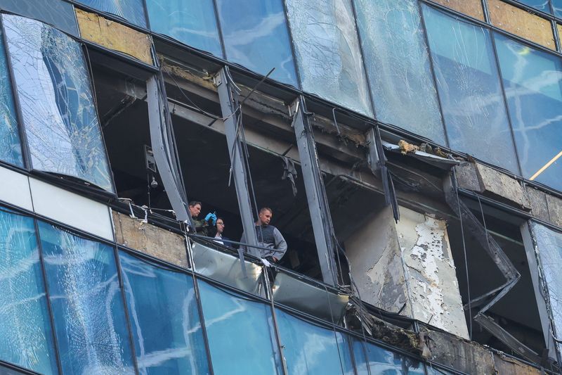 © Reuters. بعض أفراد الأمن يفحصون التلفيات التي ألحقتها ضربات وجهتها طائرات مسيرة استهدفت العاصمة الروسية موسكو صباح يوم الثلاثاء. تصوير : يفجينيا نوفوزنينا - رويترز.