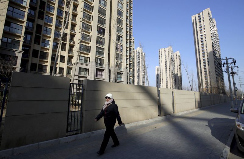 &copy; Reuters. FILE PHOTO-A woman walks past a residential compound in Beijing's Tongzhou district, China, February 25, 2016. REUTERS/Jason Lee/File Photo