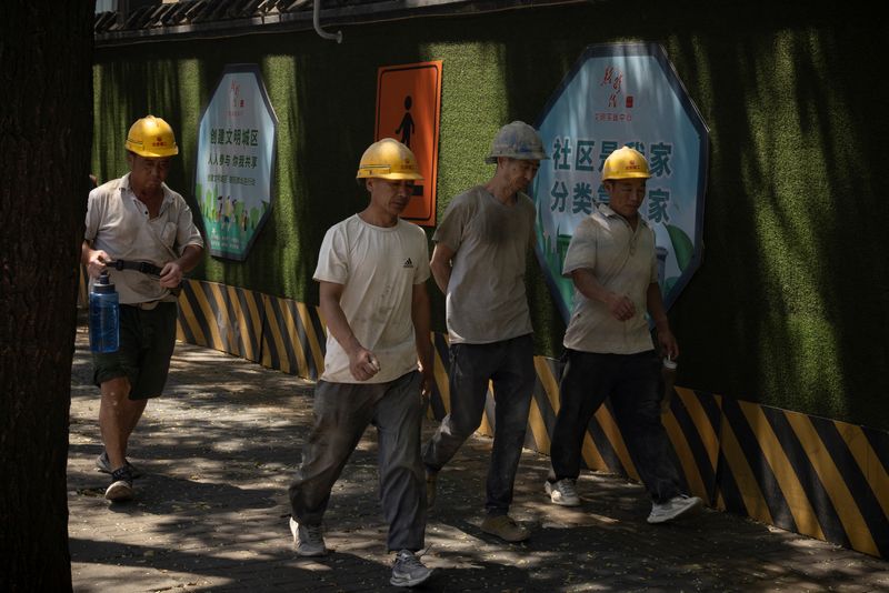 &copy; Reuters. FILE PHOTO: Workers walk in a street in Beijing, China, July 14, 2023. REUTERS/Thomas Peter/file photo