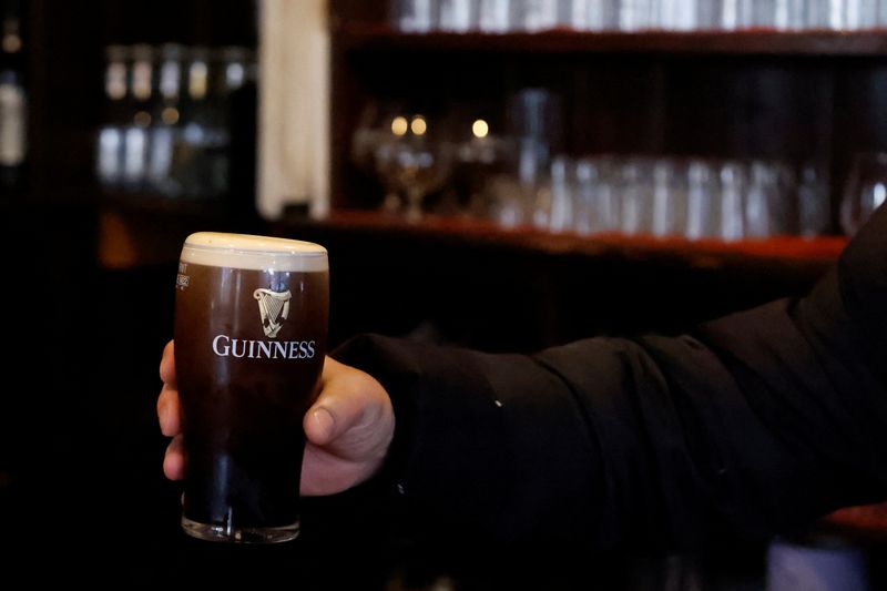 &copy; Reuters. FILE PHOTO: A customer picks up a pint of Guinness in a pub, in Dublin, Ireland March 20, 2023. REUTERS/Clodagh Kilcoyne