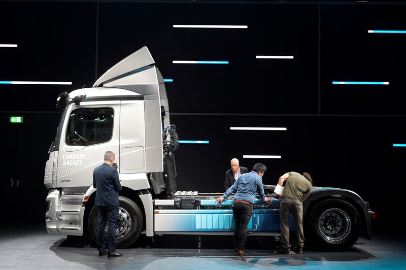 © Reuters. FILE PHOTO: Members of the media stand beside an electric driven Actros truck at the booth of German truckmaker Daimler Truck at the IAA Transportation fair, which will open its doors to the public on September 20, 2022, in Hanover, Germany, September 19, 2022. REUTERS/Fabian Bimmer
