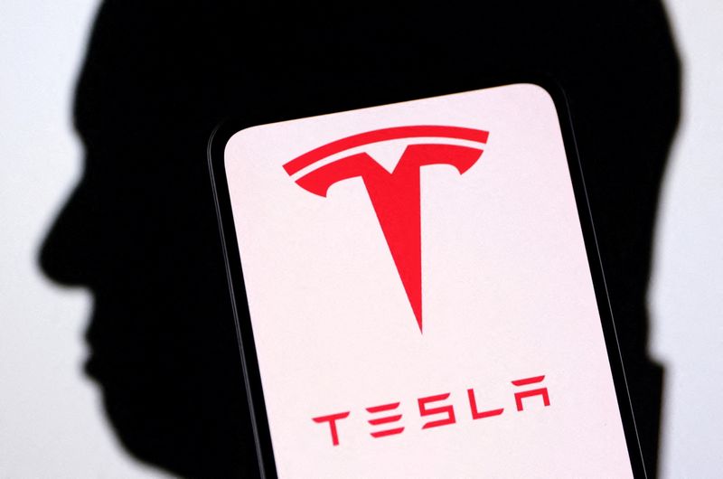 © Reuters. FILE PHOTO: Tesla logo and Elon Musk silhouette are seen in this illustration taken, December 19, 2022. REUTERS/Dado Ruvic/Illustration/File Photo