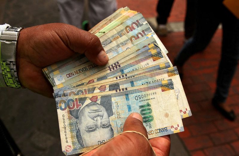 &copy; Reuters. FILE PHOTO: A money changer holds Peruvian Sol bills at a street in downtown Lima, Peru, December 15, 2017. REUTERS/Mariana Bazo/File Photo