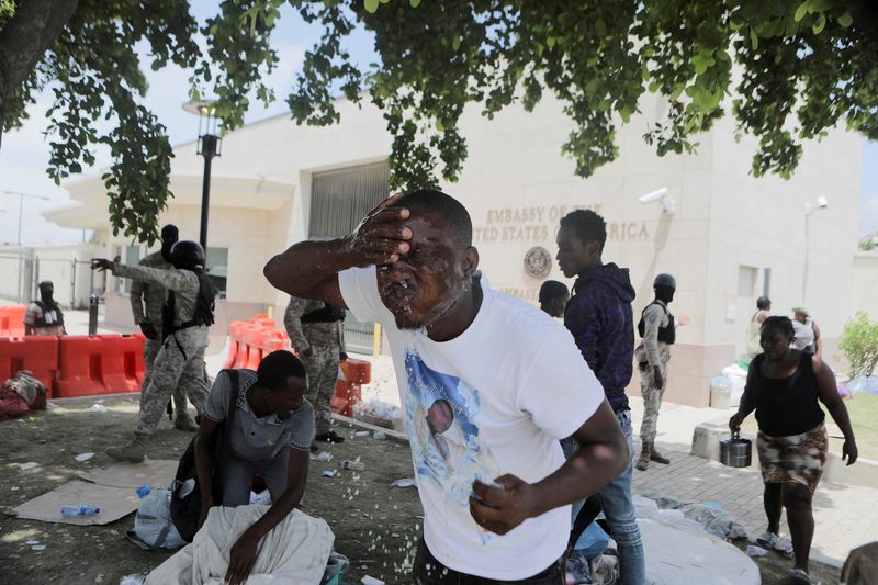 &copy; Reuters. FOTO DE ARCHIVO: Un hombre se lava la cara después de que agentes de la Policía Nacional de Haití dispararan gases lacrimógenos para desalojar un campamento de personas que escapaban de la amenaza de bandas armadas, frente a la Embajada de Estados Uni