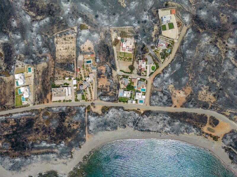 © Reuters. An aerial view of houses among burned land, as a wildfire burns on the island of Rhodes, Greece July 27, 2023. REUTERS/Nicolas Economou/File Photo