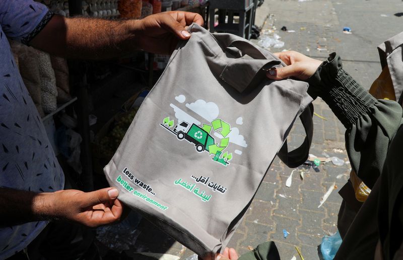 &copy; Reuters. فريق فلسطيني يوزع أكياسًا من القماش لحث السكان على تجنب استخدام الأكياس البلاستيكية وتوعيتهم بالمخاطر كخطوة في حملة جديدة صديقة للبيئة في 