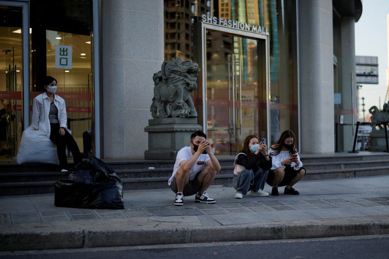 &copy; Reuters. Des personnes sur leur téléphone, à l'extérieur d'un centre commercial, à Shanghai, en Chine. /Photo prise le 19 septembre 2022/REUTERS/Aly Song