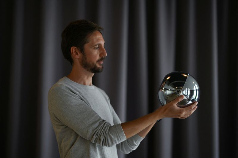 © Reuters. Ricardo Macieira, regional manager, Europe holds the biometric imaging device, the Orb of the identity and financial public utility Worldcoin in his hands, to create a World ID digital passport, being able to trade in cryptocurrency issued, in Berlin, Germany August 1, 2023. REUTERS/Annegret Hilse