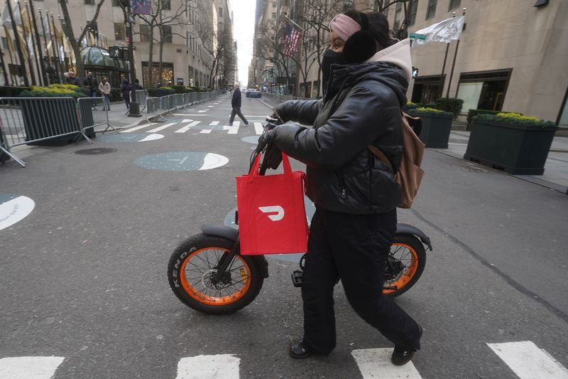 &copy; Reuters. A DoorDash delivery person is pictured on the day they hold their IPO in the Manhattan borough of New York City, New York, U.S., December 9, 2020. REUTERS/Carlo Allegri