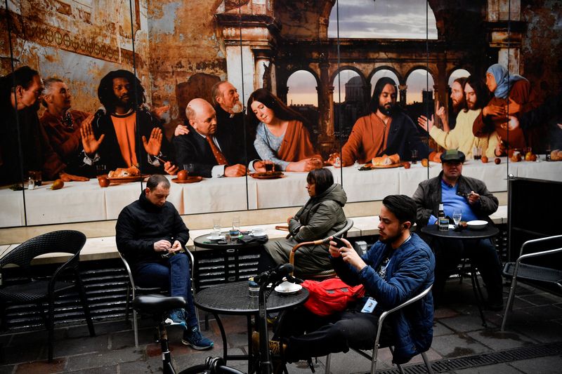 © Reuters. FILE PHOTO: People not wearing masks sit outdoor at a restaurant in the city center, as the coronavirus disease (COVID-19) restrictions begin to ease, in Dublin, Ireland January 22, 2022. REUTERS/Clodagh Kilcoyne/File Photo