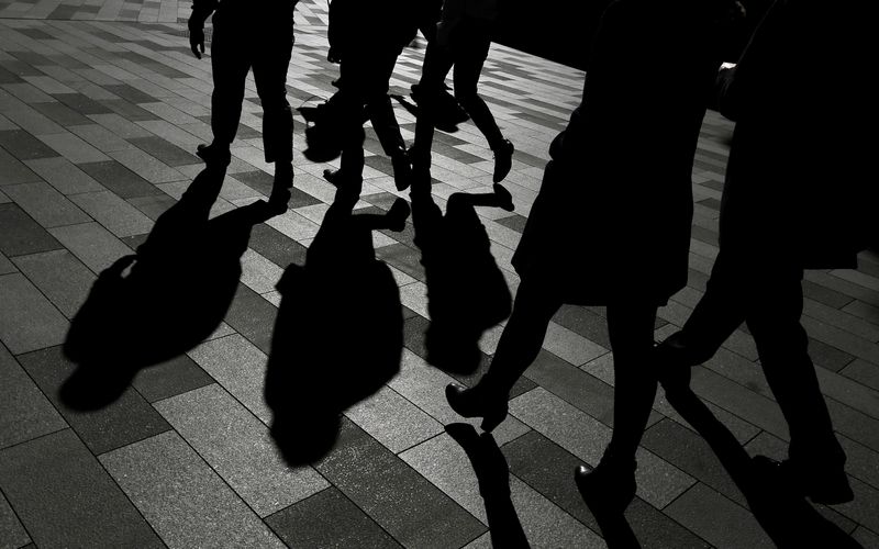 © Reuters. FILE PHOTO: Workers cast shadows as they stroll among the office towers Sydney's Barangaroo business district in Australia's largest city, May 8, 2017.  REUTERS/Jason Reed/File Photo