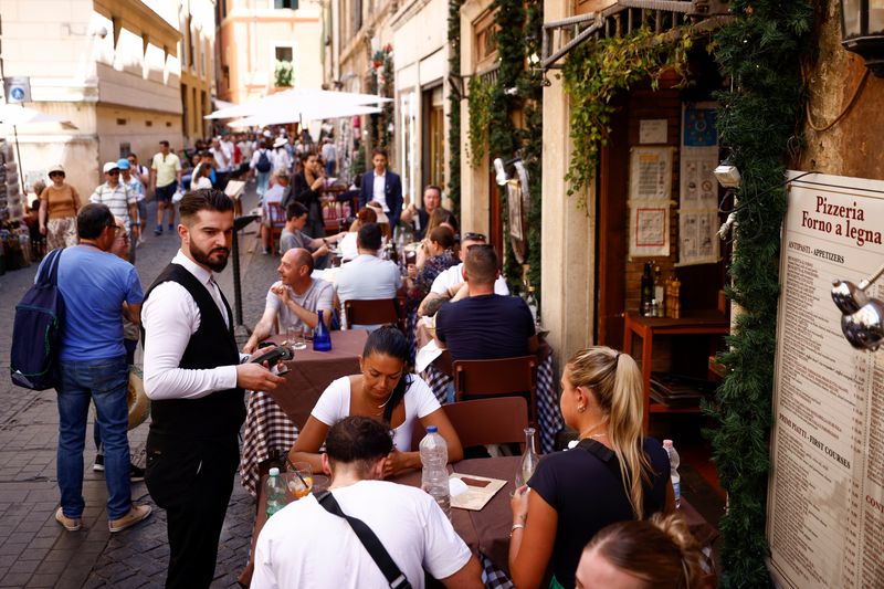 &copy; Reuters. FILE PHOTO: A waiter holds a point-of-sale (POS) device at a restaurant near the Pantheon, on the day the European Central Bank's rate-setting Governing Council holds an unscheduled meeting to discuss the recent sell-off in government bond market, in Rome