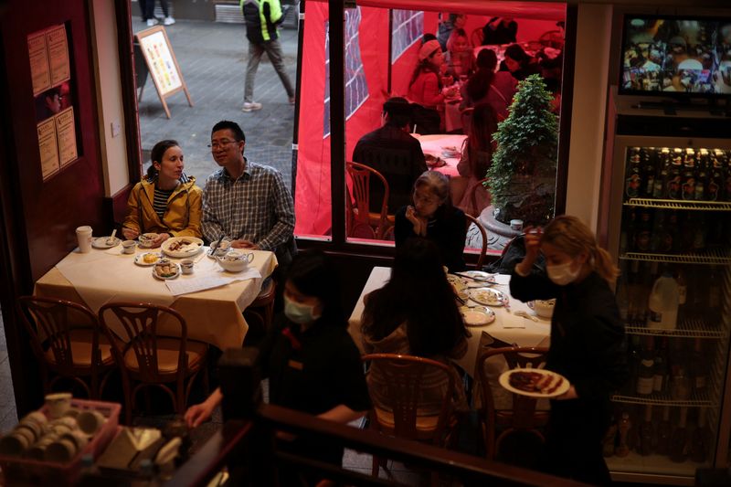 &copy; Reuters. FILE PHOTO: Waitresses work as people sit inside a restaurant, amid the outbreak of the coronavirus disease (COVID-19), in Chinatown, London, Britain, 18 May 2021. REUTERS/Hannah McKay/File Photo