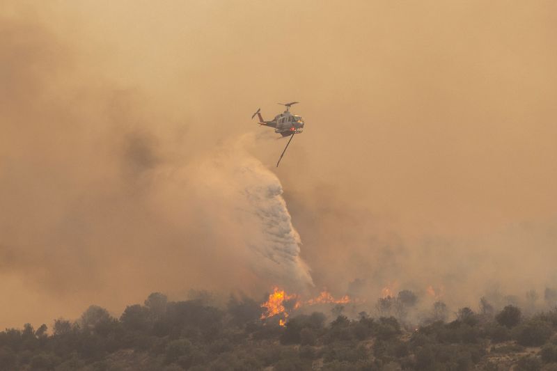 &copy; Reuters. Un elicottero antincendio getta acqua mentre un incendio colpisce Mandra, Grecia, 18 luglio 2023. REUTERS/Alkis Konstantinidis