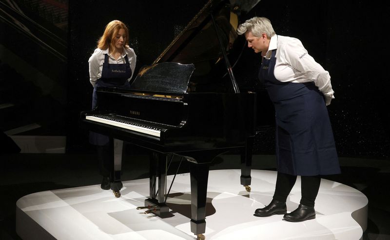 &copy; Reuters. Los encargados de Sotheby's examinan un piano de cola Yamaha que se estima que se venderá por entre 2 millones y 3 millones de euros, durante la exposición de Sotheby's 'Freddie Mercury: A World of His Own' de Sotheby's en Londres, Gran Bretaña. 3 de a