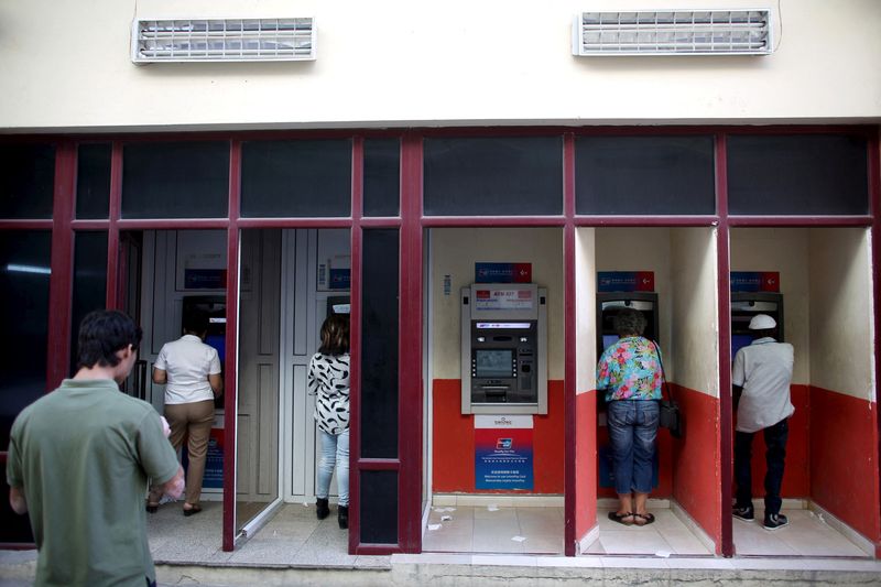 &copy; Reuters. FILE PHOTO: People  use an automated teller machine (ATM) in downtown Havana, March 15, 2016. REUTERS/Alexandre Meneghini/File Photo