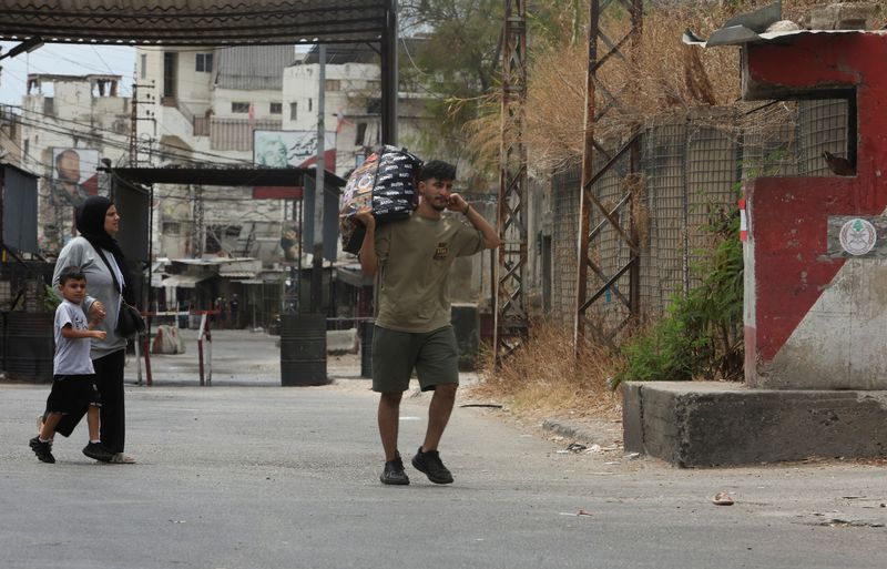 &copy; Reuters. رجل يحمل متاعه لدى نزوحه من مخيم عين الحلوة للاجئين الفلسطينيين في جنوب لبنان يوم 31 يوليو تموز 2023 خلال اشتباكات شهدها المخيم بين فصائل فلسطي