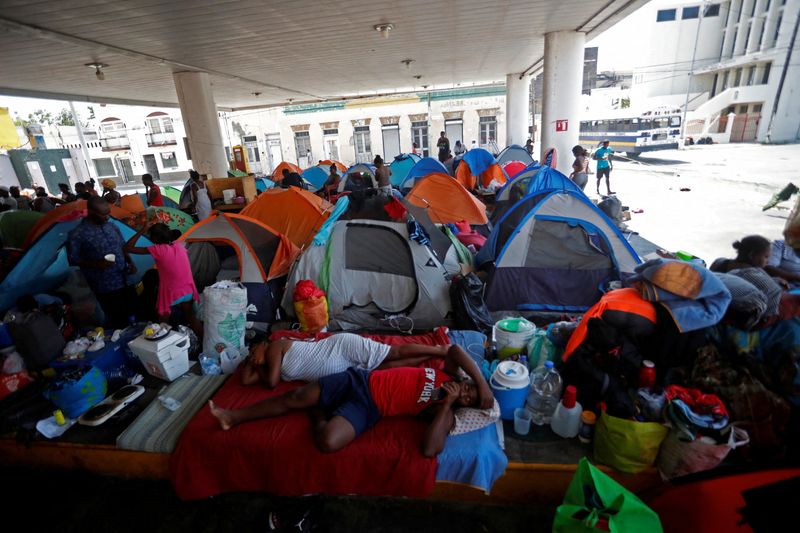 © Reuters. FILE PHOTO: Haitian asylum seekers set up camp in an abandoned gas station while they wait to attempt to cross into the U.S. by an appointment through the Customs and Border Protection app, called CBP One, at a makeshift camp, in Matamoros, Mexico June 21, 2023. REUTERS/Daniel Becerril/File Photo