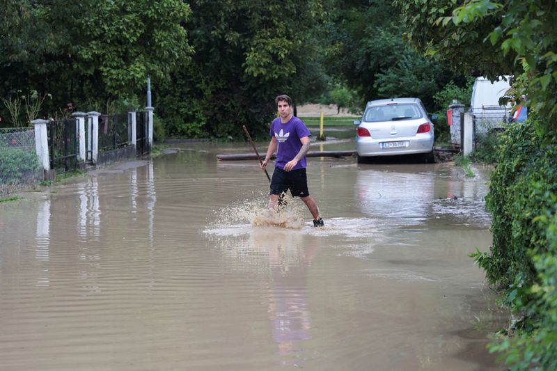 &copy; Reuters. رجل يغوص في الماء خلال فيضانات في دومزال سلوفينيا يوم الجمعة. تصوير: بوروت زيفولوفيتش - رويترز.