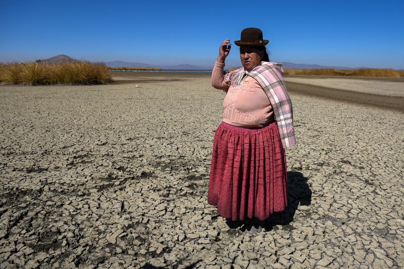 &copy; Reuters. Isabel Apaza shows the area of Lake Titicaca without water in drought season, in Huarina, Bolivia August 3, 2023. REUTERS/Claudia Morales     