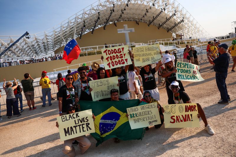 &copy; Reuters. A group of people shows posters in front of the Parque Tejo stage for the XXXVII World Youth Day, in Lisbon, Portugal August 5, 2023. REUTERS/Pedro Nunes