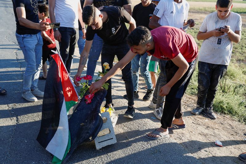 &copy; Reuters.   ８月６日、イスラエルの警察当局は、治安部隊がヨルダン川西岸でパレスチナ武装勢力の３人を射殺したと発表した。写真は同日、西岸の現場を訪れたパレスチナの人々（２０２３年　ロ