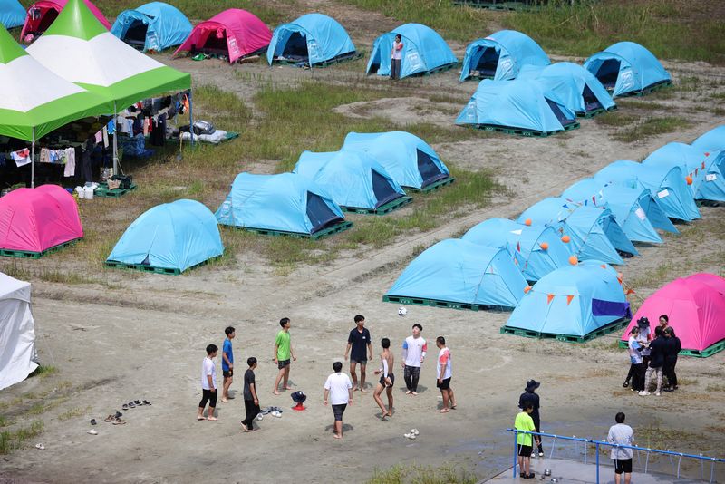 © Reuters. Participants play with a ball at the camping site for the 25th World Scout Jamboree in Buan, South Korea, August 4, 2023.   REUTERS/Kim Hong-Ji