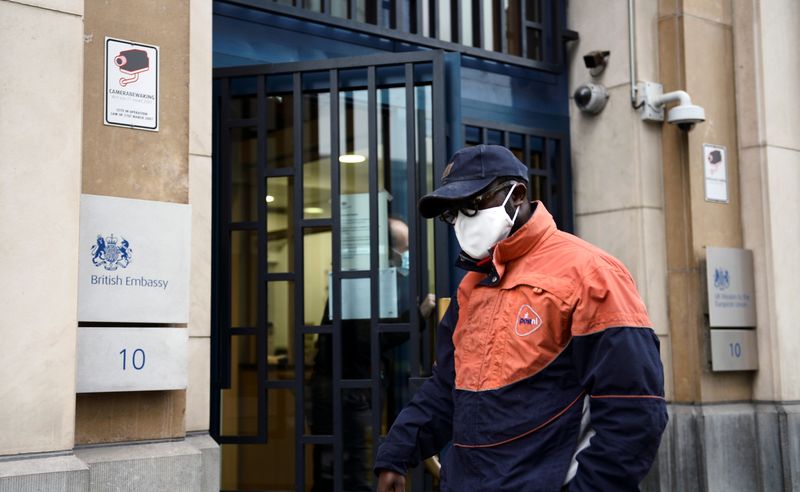 &copy; Reuters. FOTO ARCHIVO: Un empleado de PostNL en la entrada de la Misión del Reino Unido ante la UE, en Bruselas, Bélgica, 24 de diciembre de 2020. REUTERS/Johanna Geron