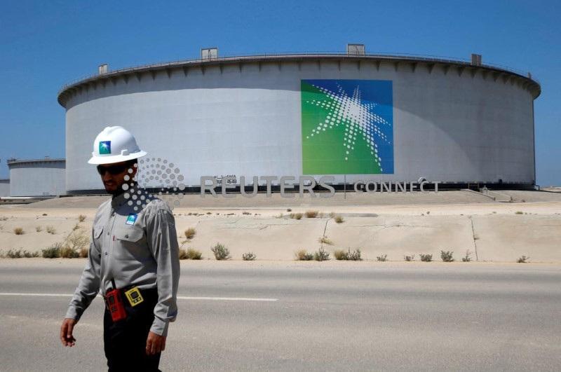 &copy; Reuters. أحد العاملين بشركة أرامكو السعودية للنفط يسير بالقرب من أحد خزانات النفط التابعة للشركة في مصفاة رأس تنورة في صورة من أرشيف رويترز 