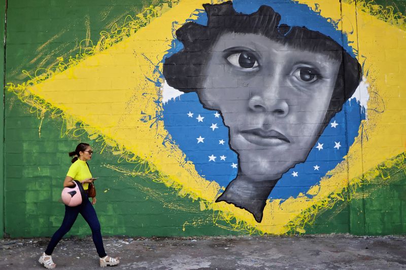 &copy; Reuters. Mulher passa por grafite com bandeira do Brasil e mapa nacional com rosto de indígena, em Belém, Pará
04/08/2023
REUTERS/Ueslei Marcelino