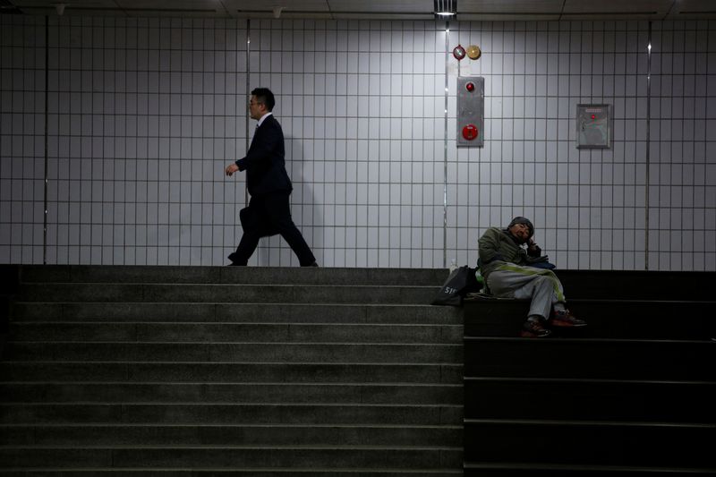 &copy; Reuters. A man walks past a homeless man at an underground shopping district in Seoul, South Korea, July 12, 2016. Picture taken on July 12, 2016.  REUTERS/Kim Hong-Ji/File photo