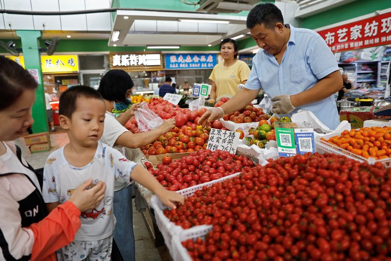 © Reuters. Customers select tomatoes at a stall inside a morning market in Beijing, China August 9, 2023. REUTERS/Tingshu Wang