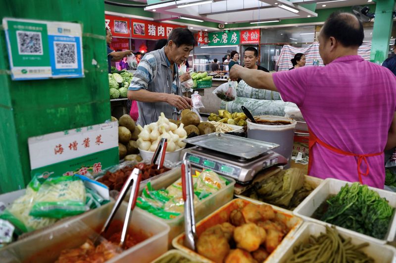 © Reuters. A pickle vendor attends to a customer at a morning market in Beijing, China August 9, 2023. REUTERS/Tingshu Wang