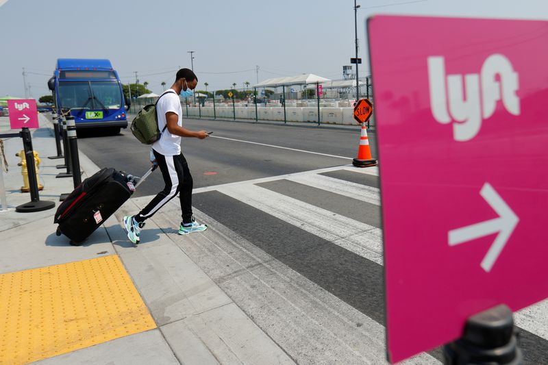 &copy; Reuters. FILE PHOTO: A traveler arriving at Los Angeles International Airport looks for ground transportation during a statewide day of action to demand that ride-hailing companies Uber and Lyft follow California law and grant drivers "basic employee rights'' in L