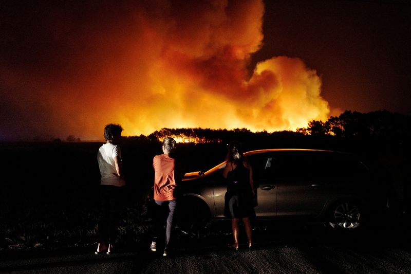 &copy; Reuters. FOTO DE ARCHIVO. Varias personas observan un incendio en la localidad portuguesa de Aljezur. 7 de agosto de 2023. REUTERS/Pedro Nunes