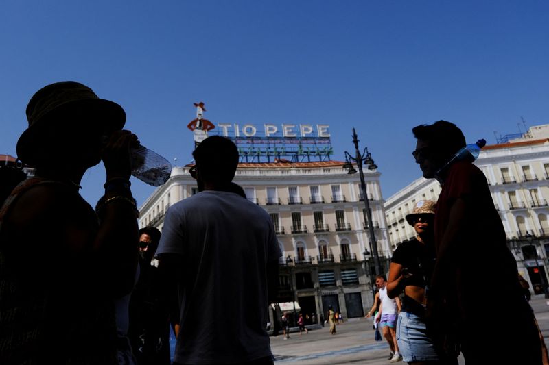 &copy; Reuters. سائحون خلال الموجة الحارة الثالثة في مدريد يوم الثلاثاء. تصوير: سوزانا فيرا - رويترز.