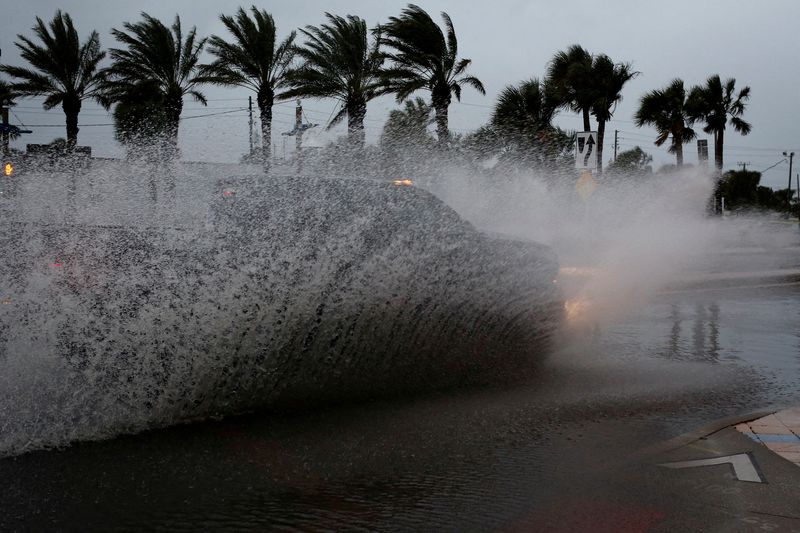 &copy; Reuters. FILE PHOTO: A car drives by a flooded street ahead of the expected arrival of Hurricane Nicole, in Daytona Beach, Florida, U.S., November 9, 2022. REUTERS/Marco Bello//File Photo