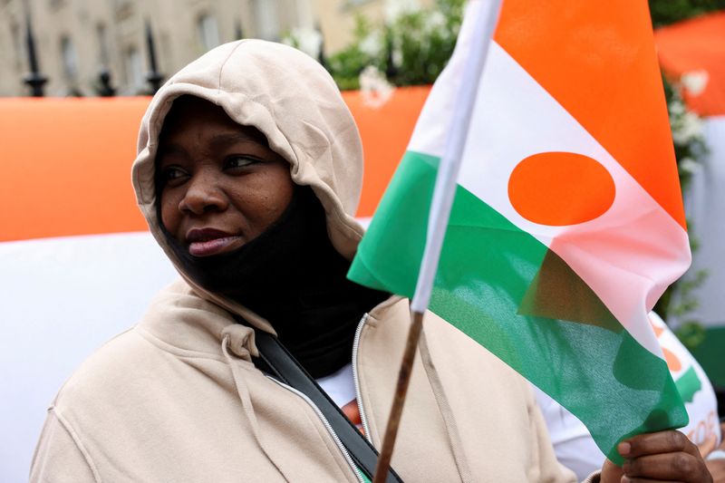 &copy; Reuters. Une personne tient un drapeau du Niger devant l'ambassade du Niger, à Paris. /Photo prise le 5 août 2023/REUTERS/Stéphanie Lecocq